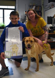 student with dog and volunteer